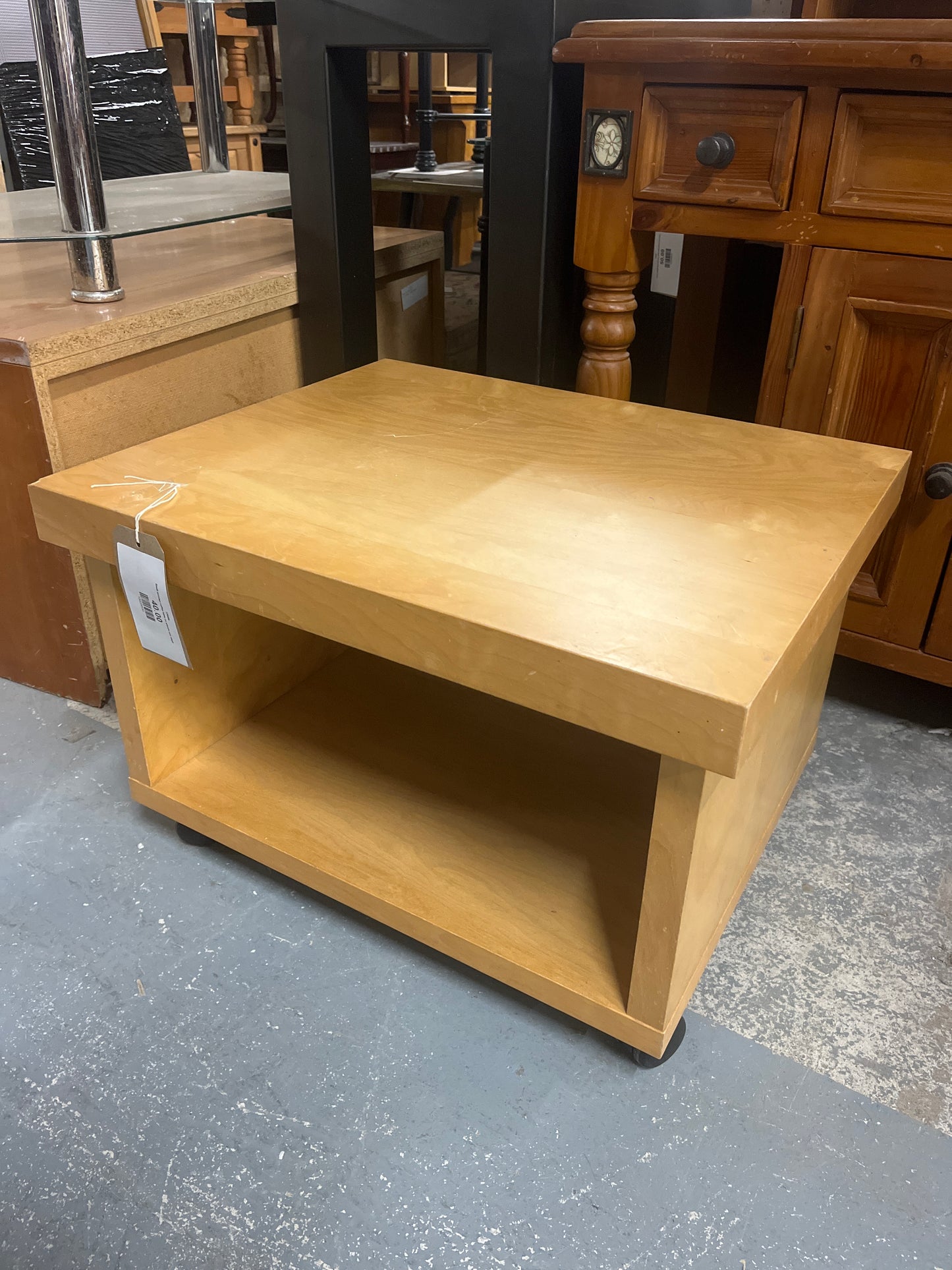 Small wooden coffee table on wheels one shelf