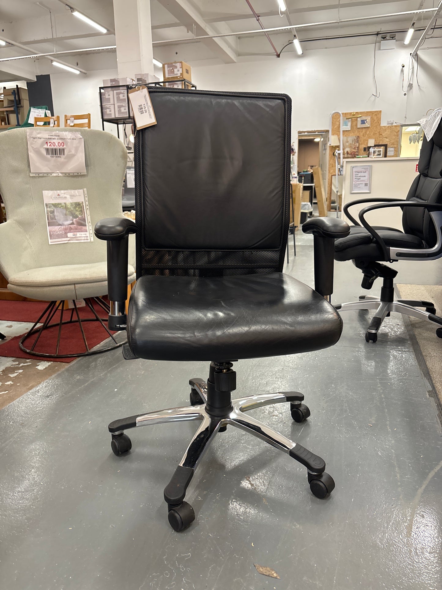 High back black leather and mesh executive swivel chair with polished metal base and height adjustable arms